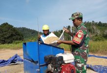Babinsa Serma Edi Sucipto Bantu Petani Giling Padi di Desa Bukit Padi