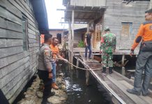 Babinsa Koramil 04/Letung Gotong Royong Bersihkan Puing Dapur Warga yang Lapuk